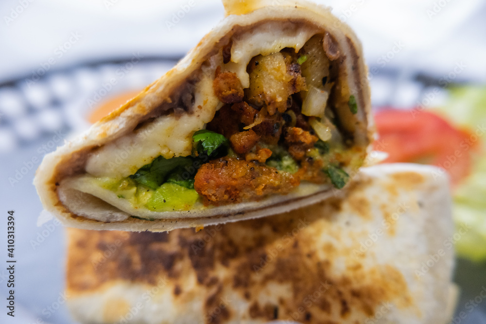 Spicy pork burritos and lettuce on a plastic basket