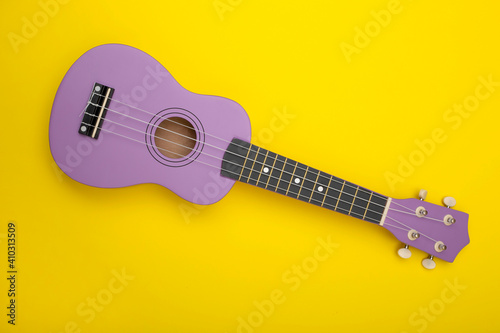 Four string ukulele guitar yellow background