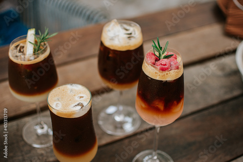 iced coffee cocktail on wooden background .Cocktail drinks a combination of cold brew coffee with juice. 
