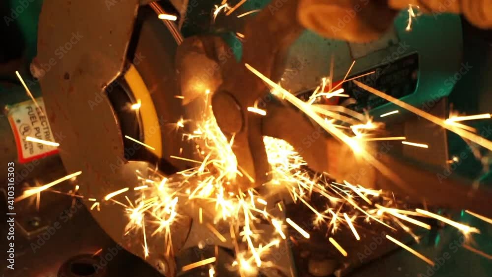 Close-up of tool sharpened on grinding wheel.  Star-shaped sparks fly off of the metal.