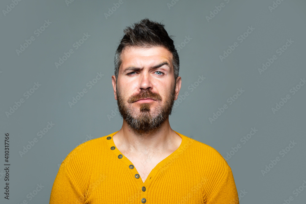 Fototapeta premium Barbershop. Serious Bearded man. Emotional portrait isolated on gray.
