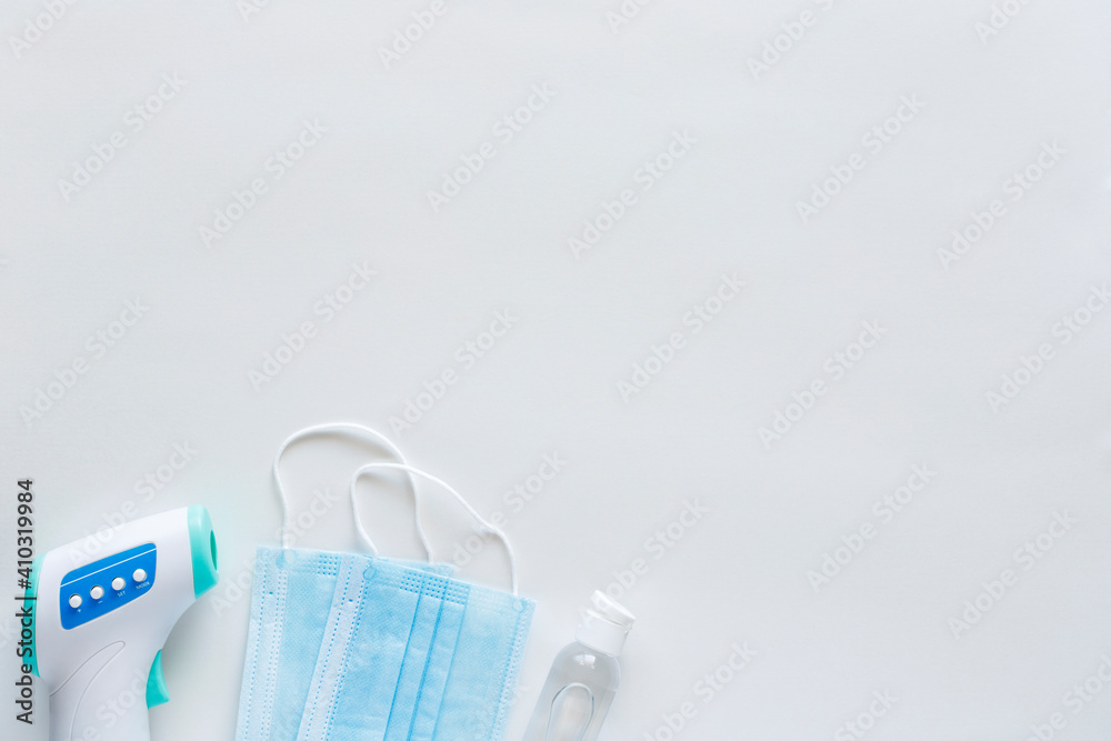 Corona virus protection concept flat lay. Disposable face masks and hand sanitizer on white background with copy space. Corona virus protection concept flat lay. Disposable face masks and hand sanitizer on white background with copy space.