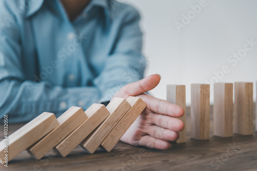 close-up hand The hand of a businessman who is stopping or preventing a falling block.Risk protection concept,Eliminating the risk