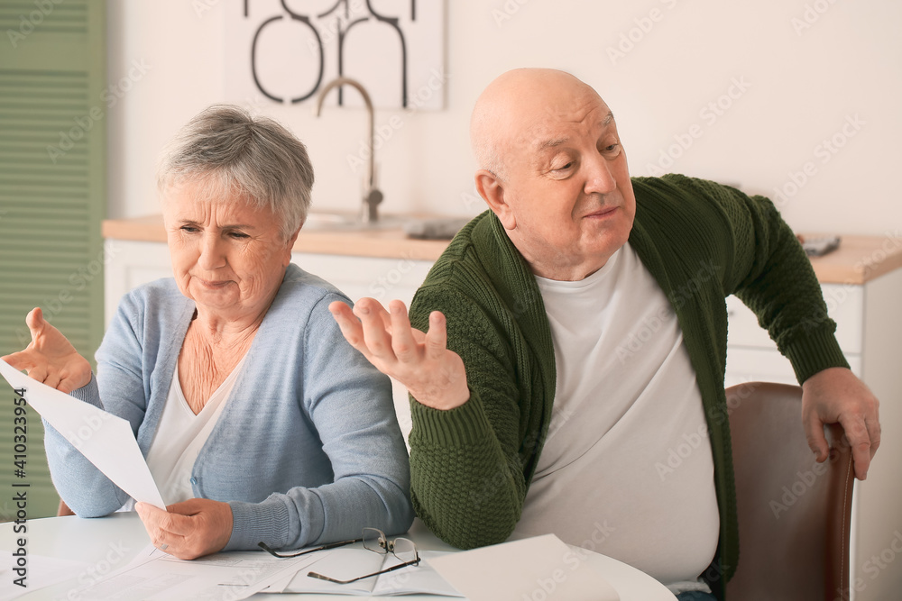 Fototapeta premium Stressed senior couple in debt at home