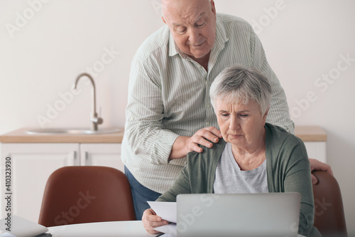 Stressed senior couple in d...