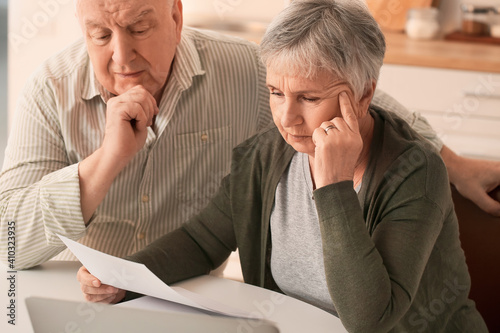 Stressed senior couple in d...