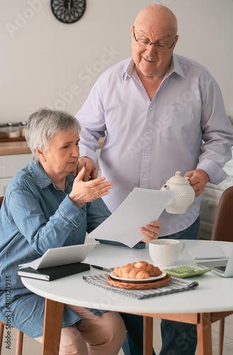 Stressed senior couple in d...
