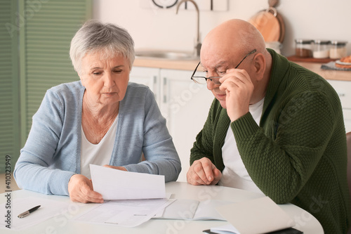 Stressed senior couple in d...