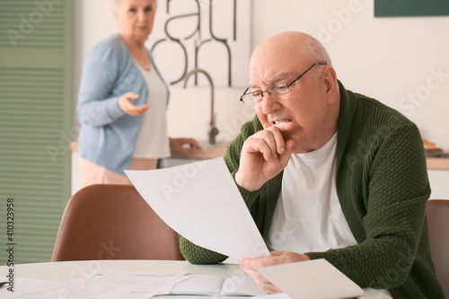Stressed senior couple in d...