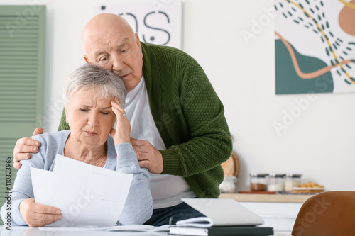 Stressed senior couple in d...