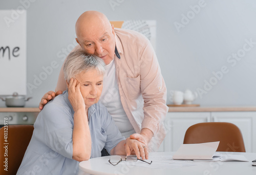 Stressed senior couple in d...