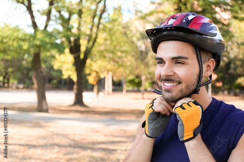 Male cyclist putting on hel...