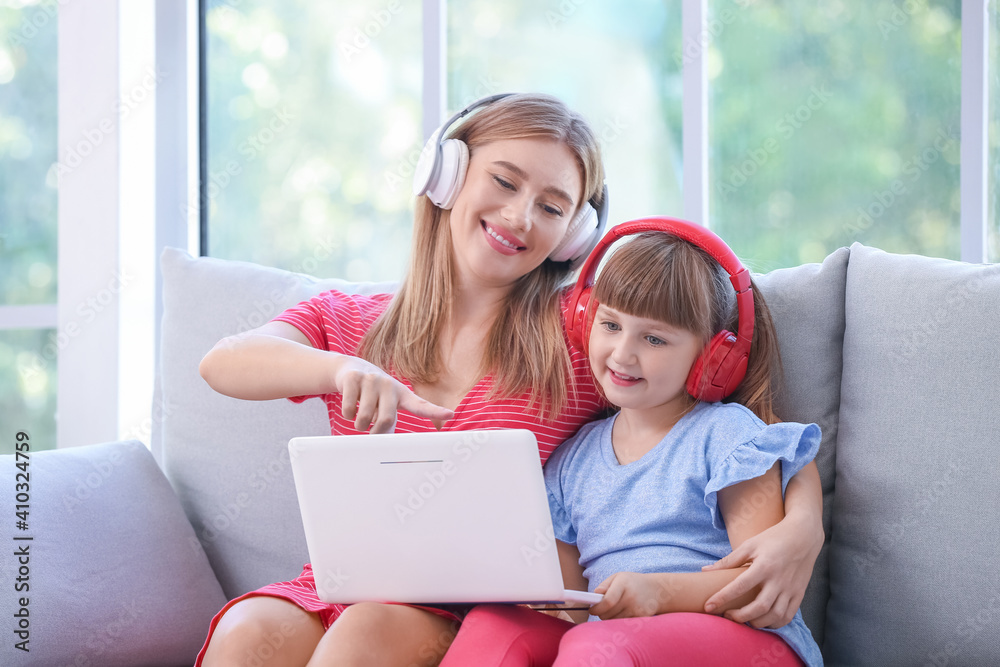 Mother and daughter with headphones and laptop at home