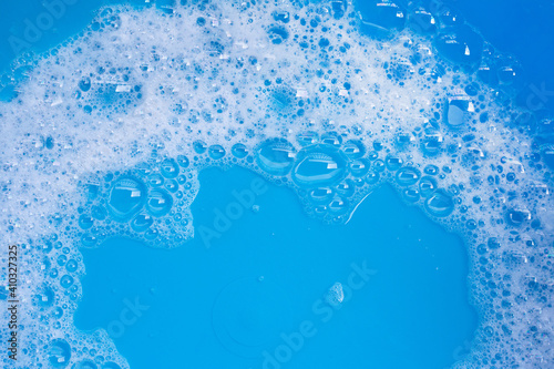 Detergent foam bubble on blue background.