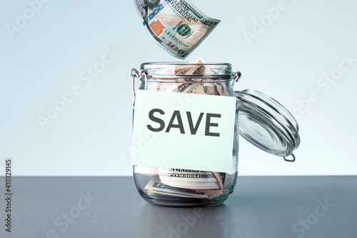 Hand putting dollars banknotes money in a jar. Saving money wealth and financial concept. photo