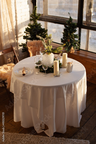 A festive day, a set table with New Year's decor. Candles and a cozy atmosphere. Christmas time. 