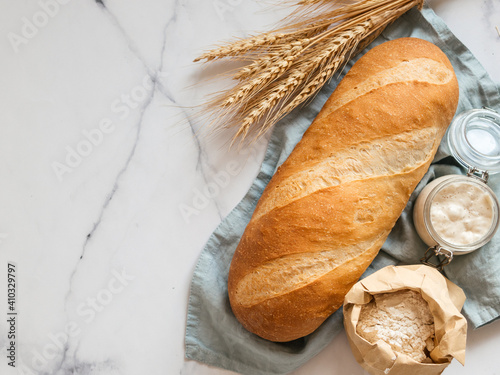 Fototapeta British White Bloomer or European sourdough Baton loaf bread on white marble background