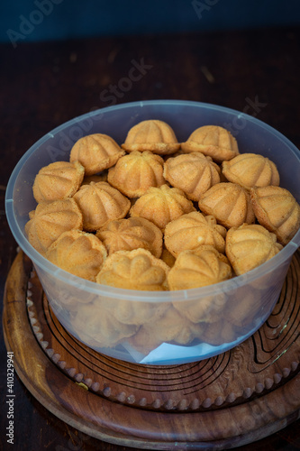 Kuih Bahulu, baulu or bolu in a container. Sponge cake baked in special aluminium moulds is the Asian tradition food in popular Malaysia and Indonesia. photo