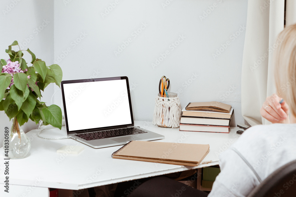 a young woman works at a computer at home. The concept of distance learning or work