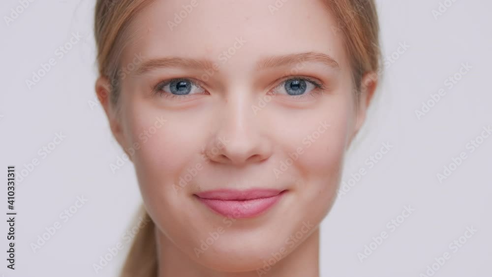 Extreme close-up beauty portrait of young light-haired woman who softly touches her face skin with her fingers from forehead through cheekbones to jawlines and looks at the camera | Beauty commercial Extreme close-up beauty portrait of young light-haired woman who softly touches her face skin with her fingers from forehead through cheekbones to jawlines and looks at the camera | Beauty commercial