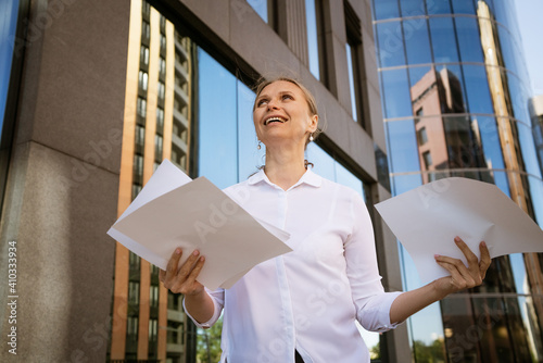 Business woman with papers in hand against the background of the office center