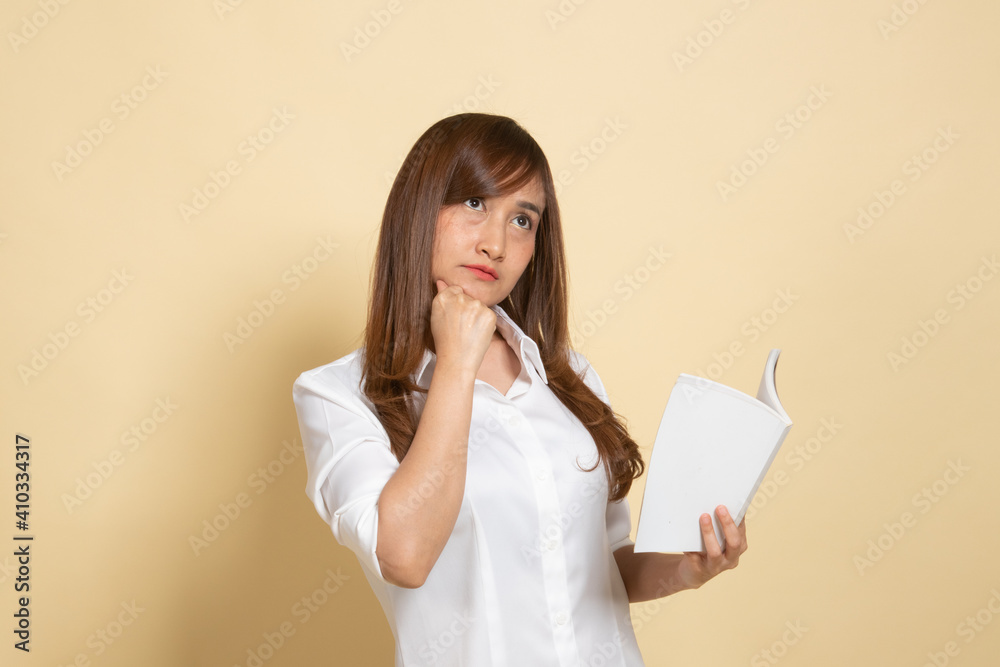 Young Asian woman with a book is thinking. Young Asian woman with a book is thinking.