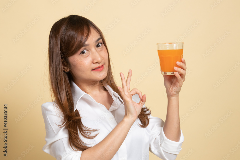 Young Asian woman show OK drink orange juice. Young Asian woman show OK drink orange juice.