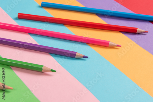 Color pencils array isolated on colour paper background