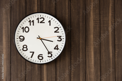 Time Clock hang on dark wooden wall background space for text