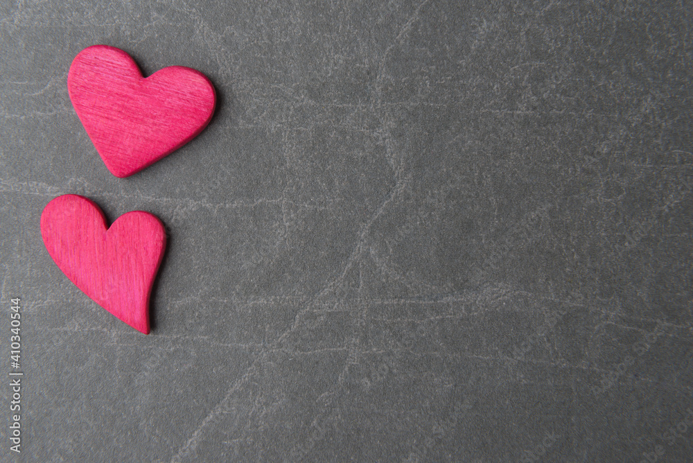 Obraz premium Two pink decorative hearts on grey stone background with copy space. Valentine’s day concept