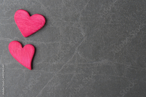 Two pink decorative hearts on grey stone background with copy space. Valentine’s day concept