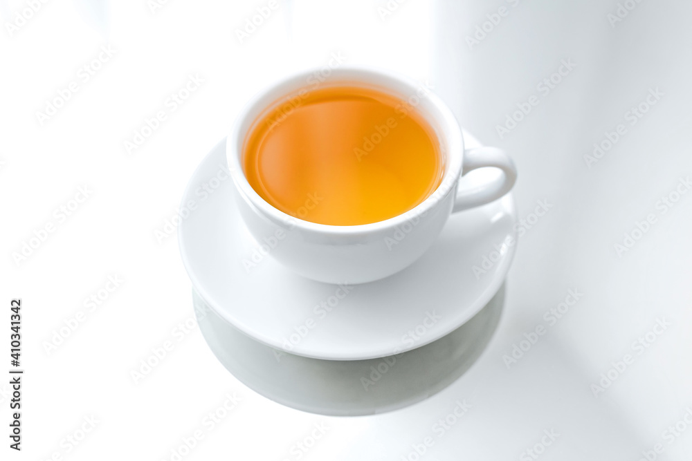 A horizontal photo of a white porcelain cup of green tea on a saucer, on a mirror table, a reflection A horizontal photo of a white porcelain cup of green tea on a saucer, on a mirror table, a reflection