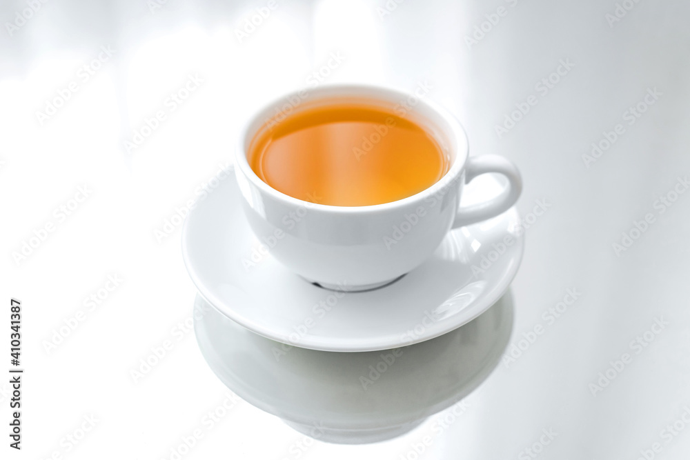 A horizontal photo of a white porcelain cup of green tea on a saucer, on a mirror table, a reflection A horizontal photo of a white porcelain cup of green tea on a saucer, on a mirror table, a reflection