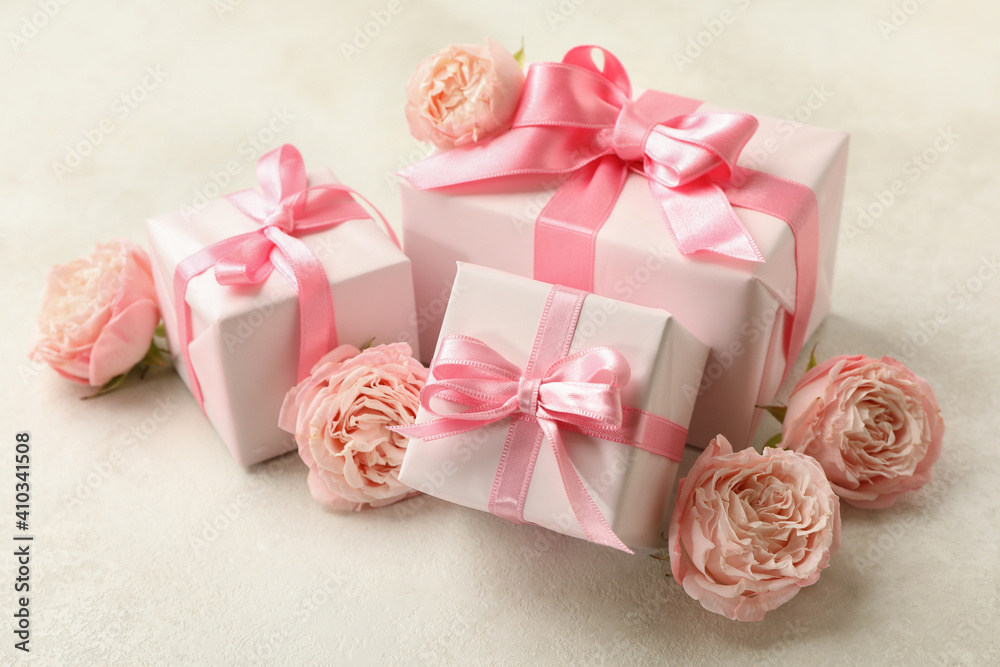 Gift boxes and roses on white textured background, close up Gift boxes and roses on white textured background, close up