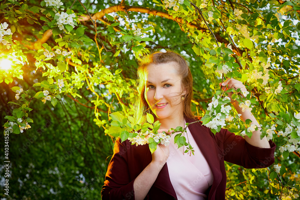 Beautiful woman with long hair walking in the park with blooming apple trees Beautiful woman with long hair walking in the park with blooming apple trees