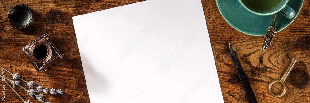 Stationery panorama with copy space, ink, with a cup of tea, shot from above on a dark rustic wooden background Stationery panorama with copy space, ink, with a cup of tea, shot from above on a dark rustic wooden background