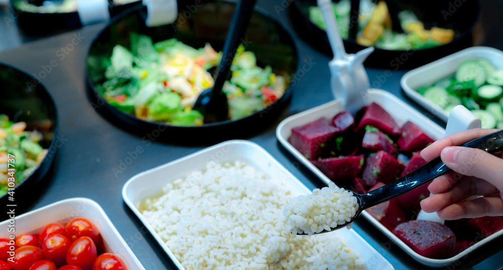 Hand holding spoon with boiled Job's tears at salad bar. Salad bar buffet at the restaurant. Fresh salad bar buffet for lunch or dinner. Healthy food. Catering food. Banquet service. Vegetarian food. Hand holding spoon with boiled Job's tears at salad bar. Salad bar buffet at the restaurant. Fresh salad bar buffet for lunch or dinner. Healthy food. Catering food. Banquet service. Vegetarian food.