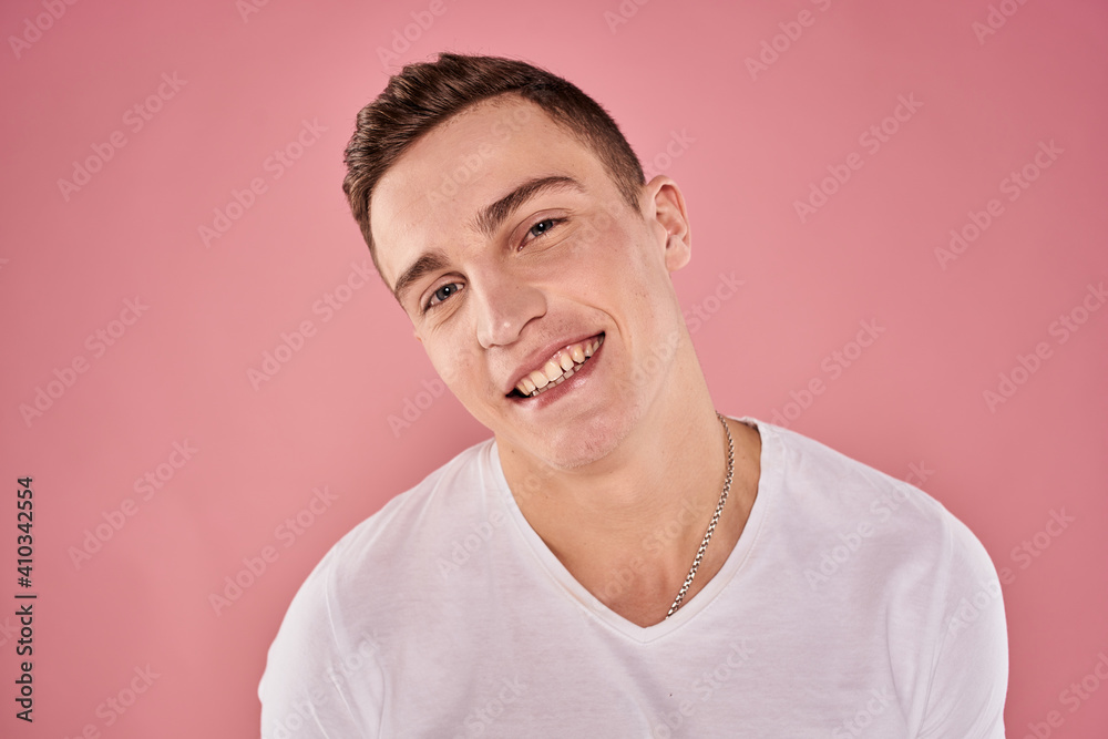 Fototapeta premium cheerful man in white t-shirt smile emotions close-up pink background studio