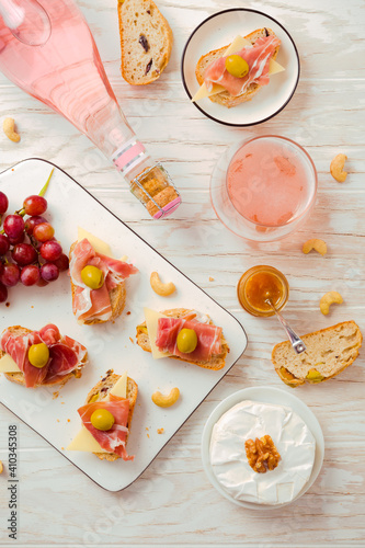 Flat lay of Appetizers and open sandwiches with Italian antipasti, camembert, Parma ham and rose wine