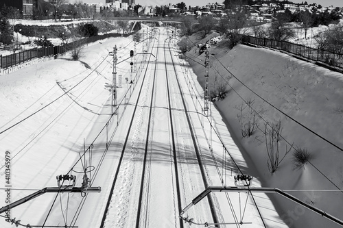 Train tracks in the snow on a cold winter's day. Black and white.