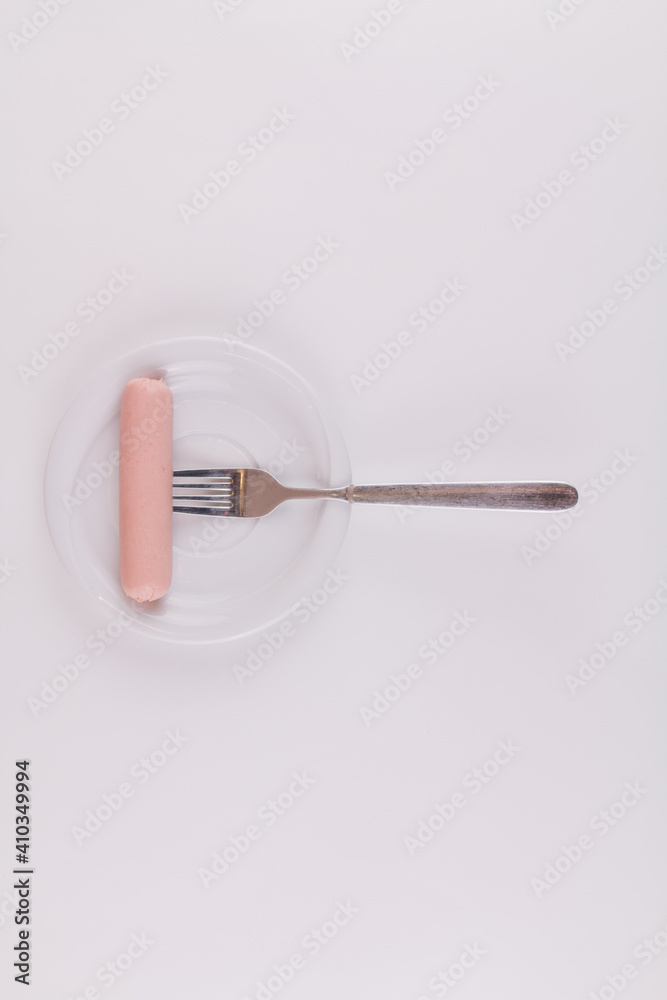 raw sausage with fork on white plate on white background raw sausage with fork on white plate on white background