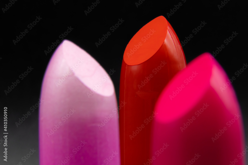 Pink, deep red, and fuchsia, magenta colored perfect, new lipstick with black background. Advertising, wallpaper, desktop shot for beauty, make up. Pink, deep red, and fuchsia, magenta colored perfect, new lipstick with black background. Advertising, wallpaper, desktop shot for beauty, make up.