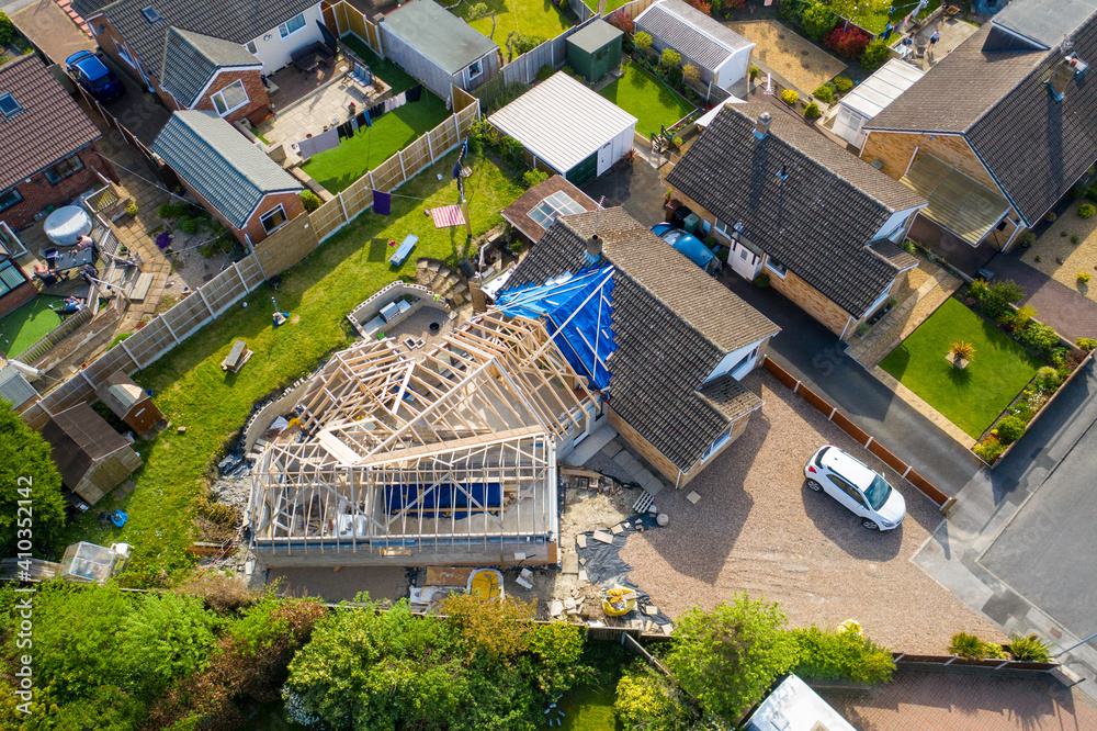 Obraz premium Aerial photo of a typical british housing esate in the Village of Kippax in Leeds West Yorkshire, suburban housing estates and road in the village showing an extension being built on a property