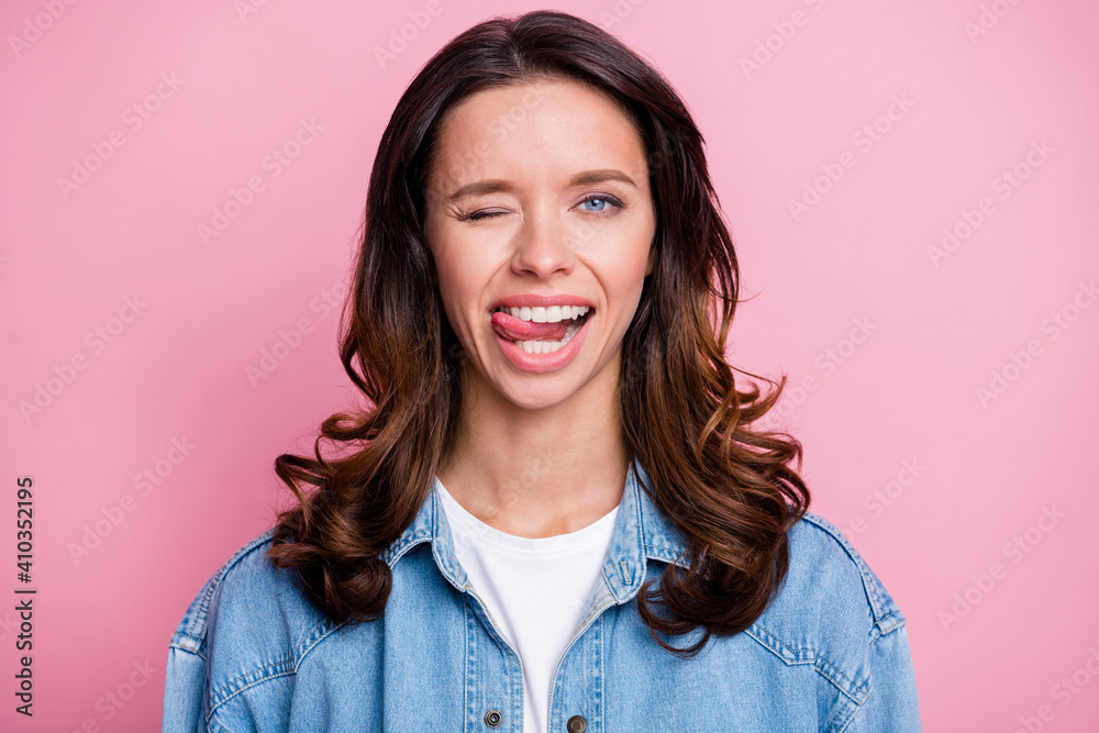 Fototapeta premium Photo of cute attractive flirty young woman bite tongue wink eye isolated on pastel pink color background