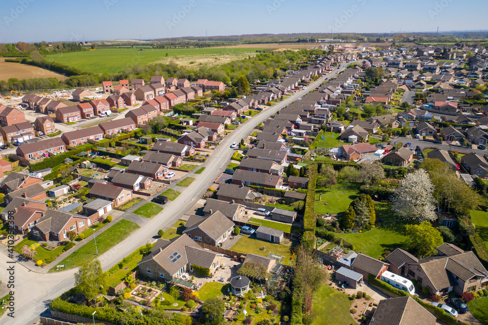 Aerial photo of the town of Kippax in Leeds West Yorkshire in the UK showing residential housing estates on a beautiful sunny summers day with white fluffy clouds in the sky.