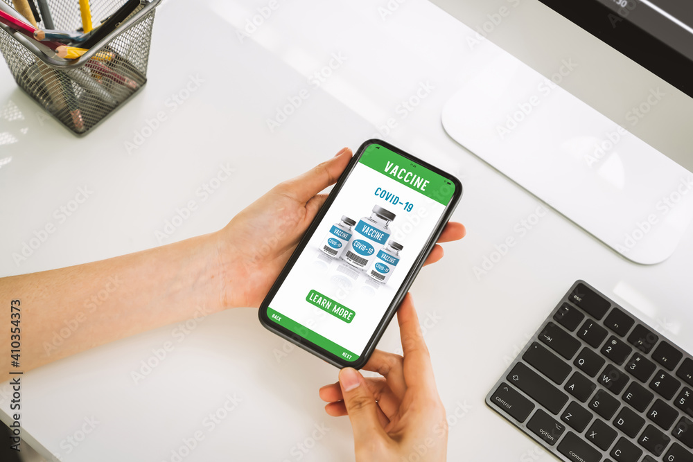Hand holding smartphone and show web page corona vaccine online with learn more button. Hand holding smartphone and show web page corona vaccine online with learn more button.