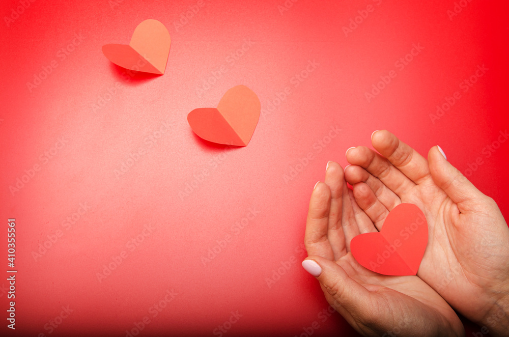 Fototapeta premium three red paper hearts on a red background