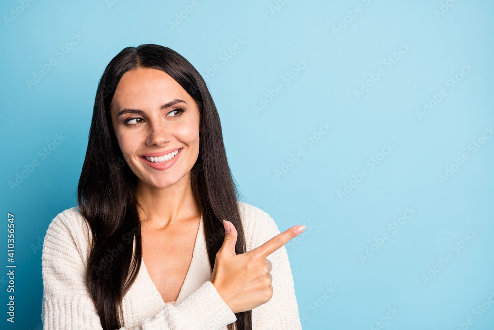 Portrait of cheerful young person look direct finger empty space promotion isolated on blue color background Portrait of cheerful young person look direct finger empty space promotion isolated on blue color background