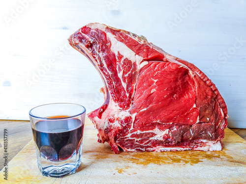 beef steak on the bone, ready for your barbeque and lunch, with a glass of good genuine wine photo