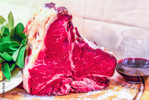 beef steak on the bone, ready for your barbeque and lunch, with a glass of good genuine wine photo